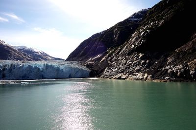Scenic view of waterfall and mountains against sky