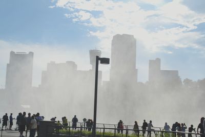 Panoramic view of people in city against sky