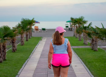 Rear view of woman walking on footpath