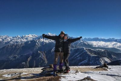 Man standing on snowcapped mountain against clear sky