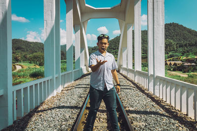 Portrait of young man standing on railroad track