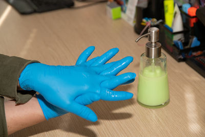 Close-up of hand holding bottle on table