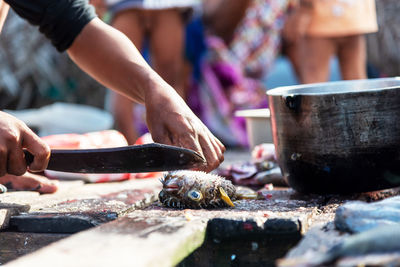 Midsection of man cutting meat on table