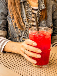 Midsection of woman drinking beer glass