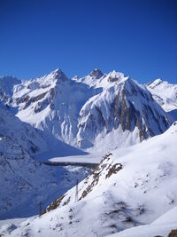 Scenic view of snowcapped mountains against clear blue sky