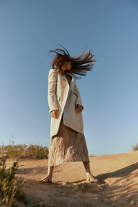 Rear view of woman standing against sky