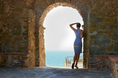 Rear view of woman standing against wall