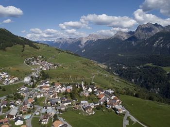 Scenic view of townscape and mountains against sky