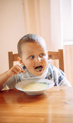 Portrait of smiling boy sitting on table