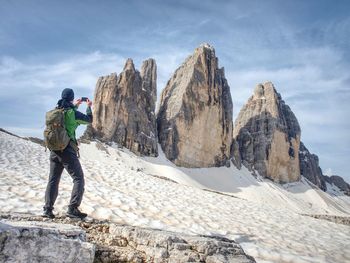Hiker with backpack climbing on mountain peak. summits of dolomites alps mountains. tourist walk