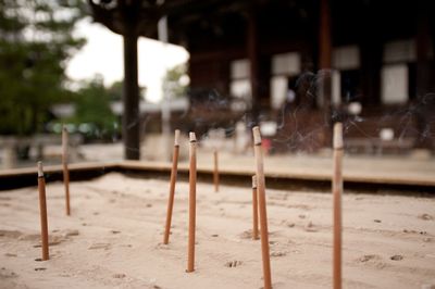 Incense sticks in sand outside temple