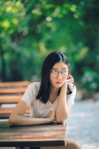 Portrait of young woman sitting on table