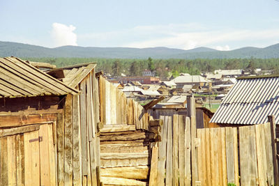 View of wooden house and mountains against sky