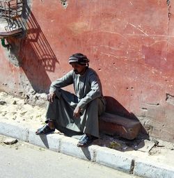 Full length of man sitting outdoors