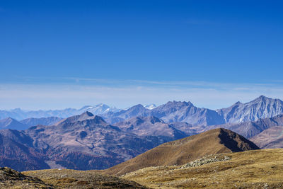 Scenic view of mountains against blue sky