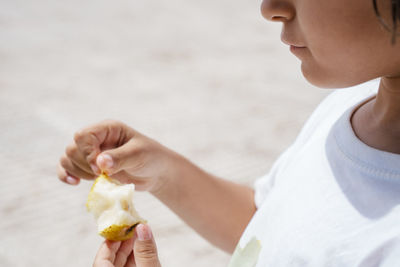 Midsection of girl eating fruit