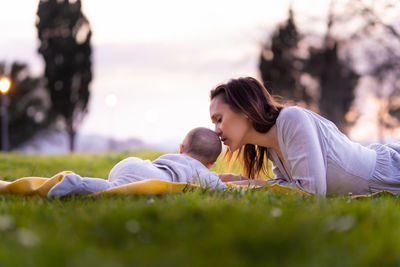 Mother and son lying on grass at park