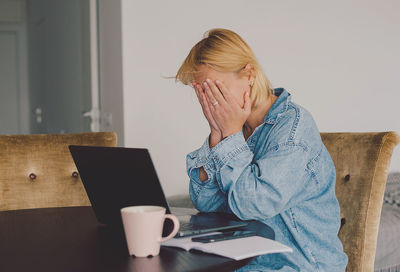 Young woman using laptop while sitting at home