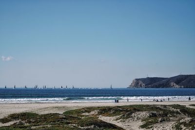 Scenic view of beach and sea against clear sky