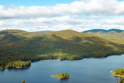 Scenic view of lake by mountains against sky