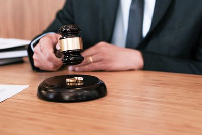 Close-up of judge hammering rings on table 