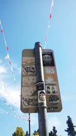 Low angle view of sign board against blue sky