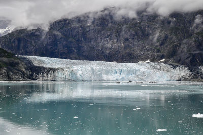 Ancient glacier and foggy dramatic sky in alaska ocean bay
