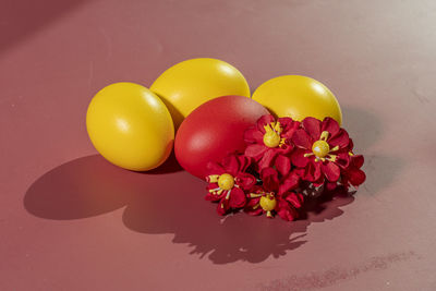 Colorful eggs symbolizing easter on a colorful background and flowers