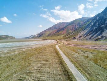 Road leading towards mountains against sky