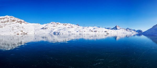 Scenic view of snowcapped mountains against clear blue sky