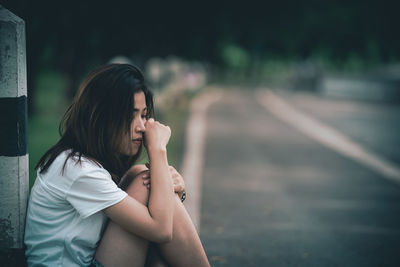 Side view of young woman looking away outdoors