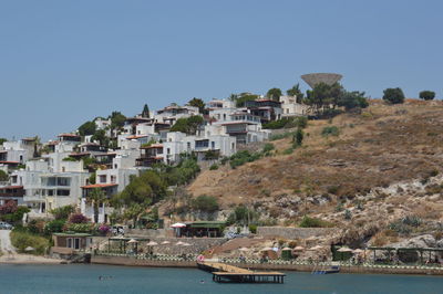 Town by sea against clear blue sky