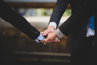 Midsection of couple holding hands