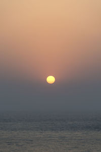 Scenic view of sea against orange sky