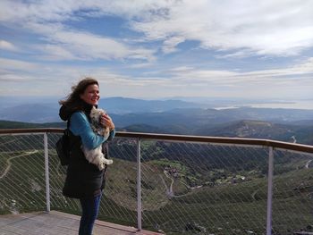 Full length of woman standing on railing against mountain