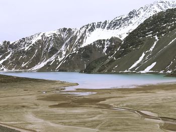 Scenic view of lake by mountains against sky