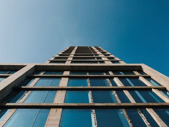 Low angle view of modern building against clear blue sky