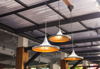 Low angle view of illuminated pendant light hanging from ceiling