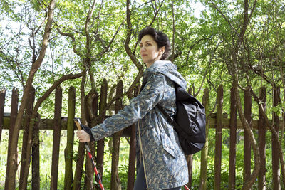 Nordic walking. young caucasian woman walks with sticks, trekking poles and backpack, physical
