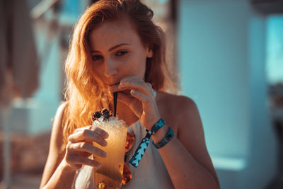 Portrait of beautiful woman drinking cocktail