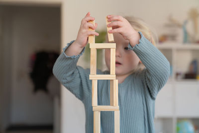 A toddler girl building a tower really focused