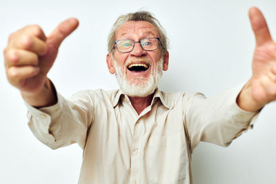 Portrait of cheerful senior man gesturing against white background