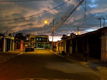 Cars on road amidst buildings against sky in city