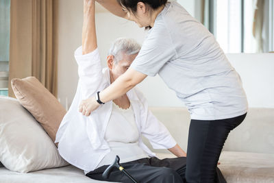 Midsection of couple sitting at home