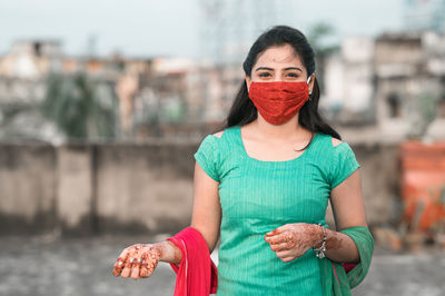 Portrait of young woman standing in city