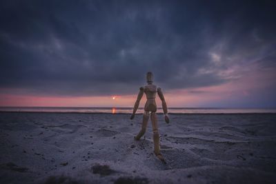 Boy on beach against sky at night