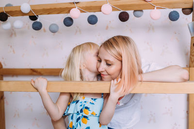 Little cute girl child blonde at home in her wooden bed house