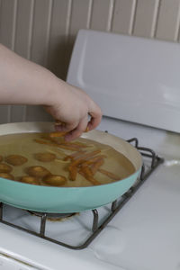 Midsection of woman preparing food in kitchen at home