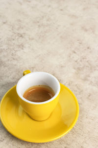 Espresso on yellow cup, fresh make one shoot espresso coffee 