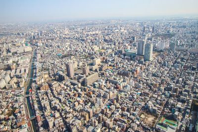 Aerial view of buildings in city against sky